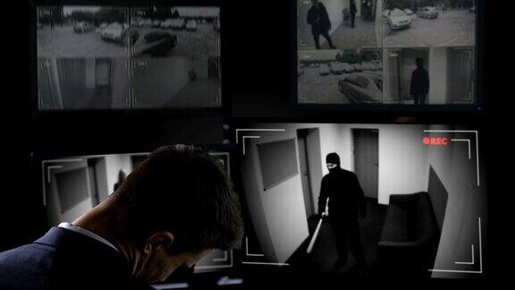 一名男性保安在闭路电视录像前睡觉歹徒在大楼里刹车
