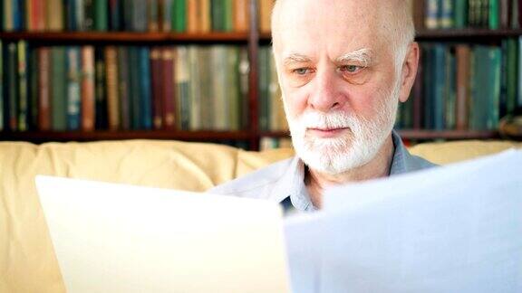 英俊的老年人在家里用笔记本电脑工作退休后从事远程自由职业