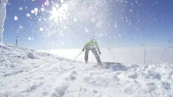 在一个阳光明媚的冬日里慢动作滑雪者在山顶上开始滑雪