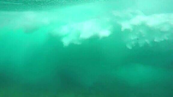 水下慢动作:美丽的大管波打破摄像机