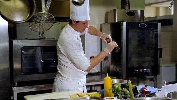 一名男厨师在餐厅厨房里在碗里腌制蔬菜