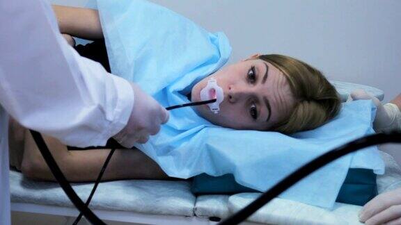 医生通过一个年轻女孩的嘴做一个胃镜检查管