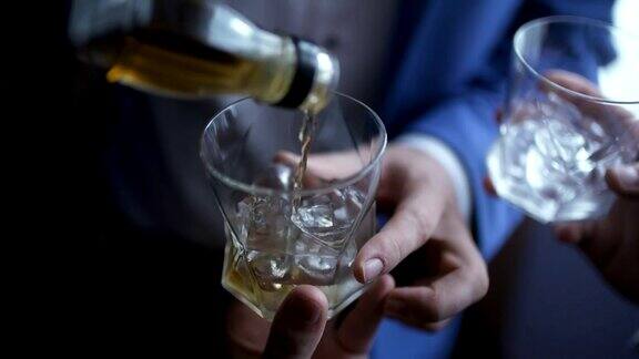 优雅的商人将威士忌倒进玻璃杯