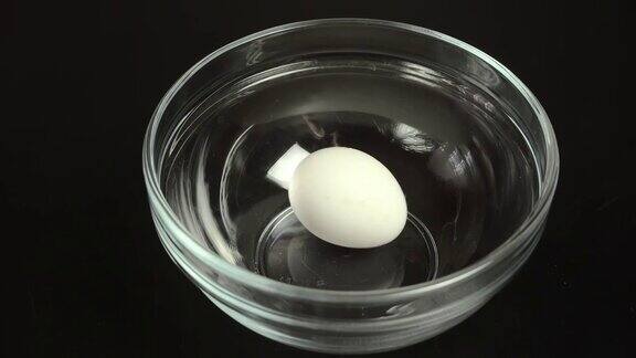 白色的鸡蛋在盘子上旋转特写镜头从以上观点