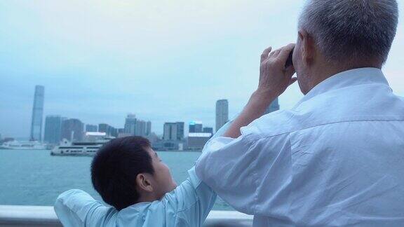 可爱的孙子盖住了爷爷的望远镜