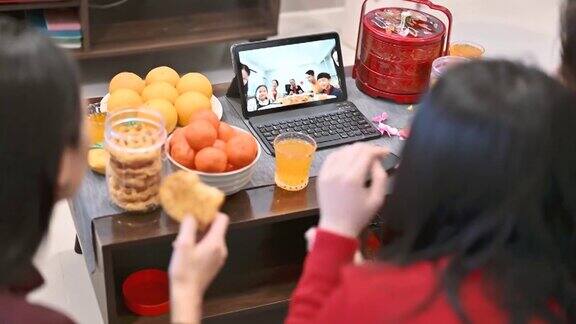 快乐的亚洲家庭在网上祝贺中国新年并在家里通过数码平板电脑视频电话与亲戚团聚
