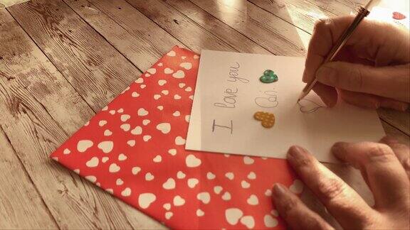 一个女人的手在情人节卡片上画了一颗心情人节