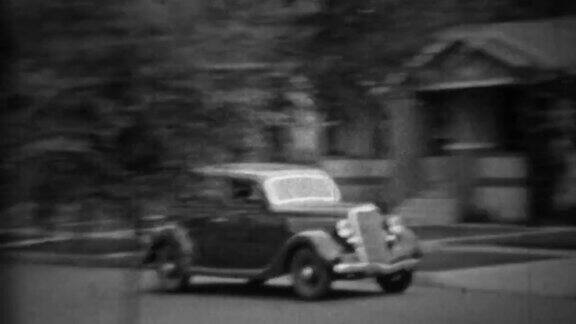 1935年:经典新款黑色普利茅斯轿车开在居民区