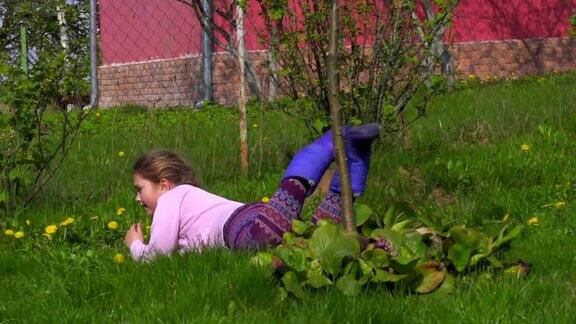 一个小女孩在草地上打滚洋娃娃慢动作