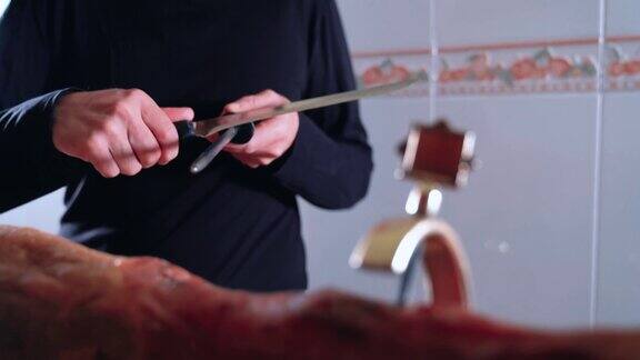 匿名人士在切火腿之前磨火腿刀非常锋利的优质刀男厨师腹部锋利的刀在厨房里4k的视频