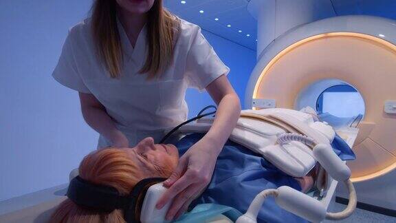 护士在做核磁共振扫描前给病人准备好耳机