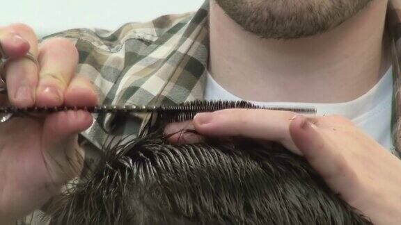理发师用梳子和剪刀修剪黑发