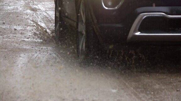 慢镜头近景:一辆SUV在泥泞的道路上行驶