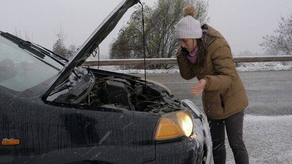 汽车在第一场雪中抛锚了在恶劣的天气下汽车会在偏僻的地方抛锚汽车保险一个女人在路上