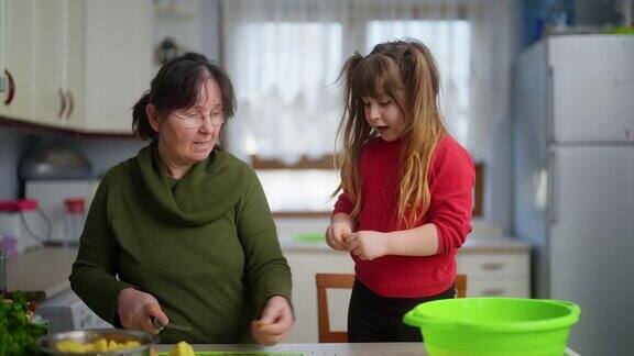 祖母和孙女在厨房里一起做饭祖母教孙女健康饮食和可持续发展