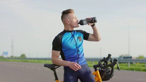 男子在骑完自行车后喝水休息