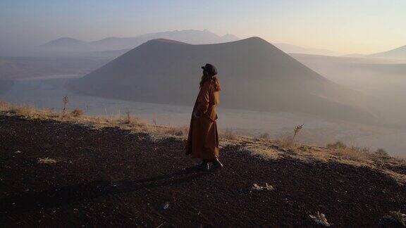 女人站在那里看着火山