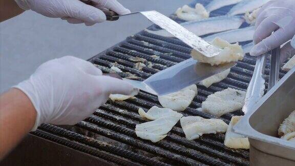 厨师在露天烤架上辛苦地煎鱼、菜油和鱿鱼烤鲭鱼片作硬鱼片