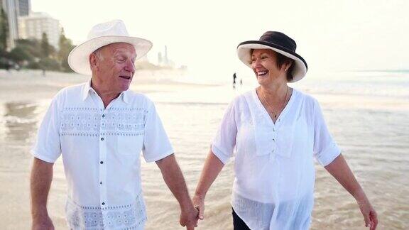 一对幸福的老年夫妇在海滩上散步