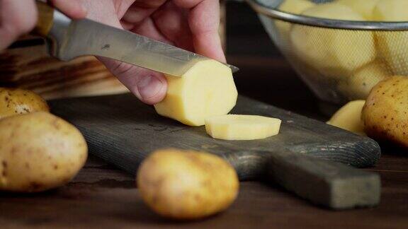 男用手用刀将新鲜土豆切成圆片