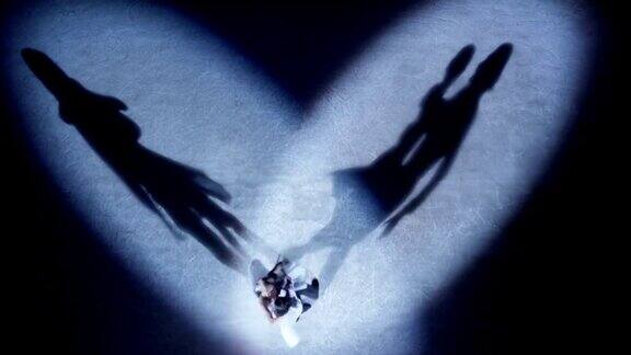 花样滑冰选手在聚光灯下表演爱情舞蹈