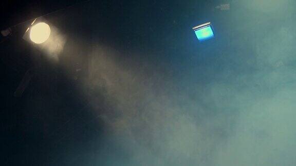 舞台上的烟雾在演出期间剧院的泛光灯发出的光线用调光开关逐渐关闭光源照明设备