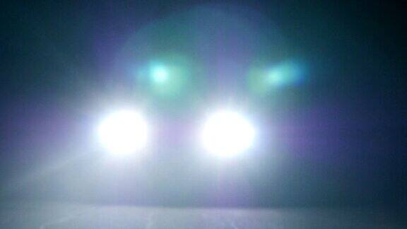 晚上开着灯的车汽车在空旷的夜里行驶在一片漆黑中只能看到汽车前灯的亮光