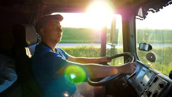 日落时分卡车司机在乡间行驶的侧面图戴着帽子的男人控制着他的卡车享受着旅程美丽的风景与明亮的阳光在背景慢镜头