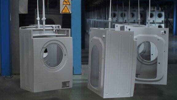 在现代化的工厂里洗衣机的机壳在自动传送带上移动