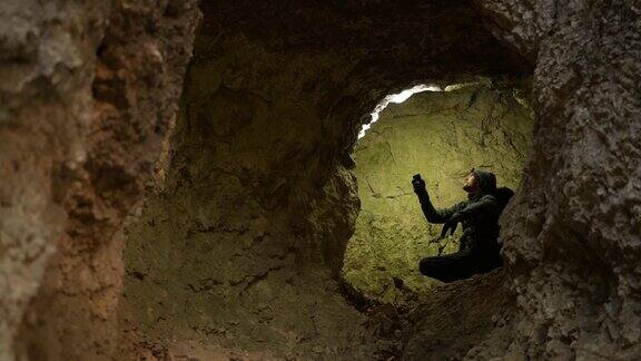 洞穴探险家用他的手电筒照亮地层岩石