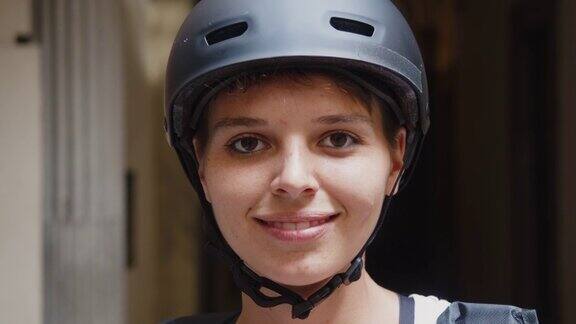 慢动作视频中一个年轻的成年妇女戴着自行车头盔睁开眼睛看着摄像机