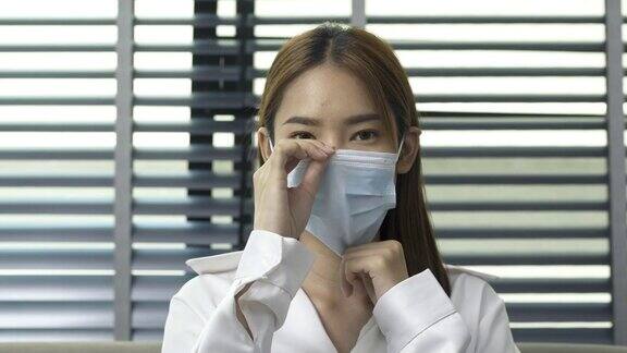 新冠肺炎疫情期间美丽的年轻女教师戴着医用口罩看着镜头