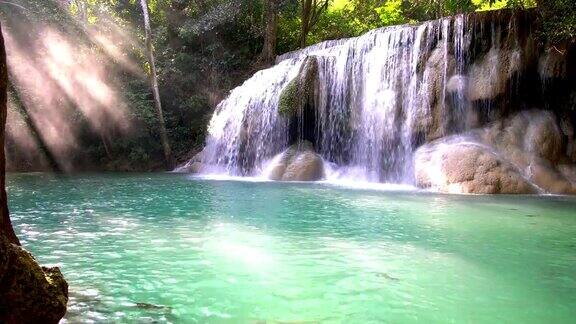 瀑布和美丽的热带自然与阳光透过树泰国北碧府四面瀑布4k分辨率