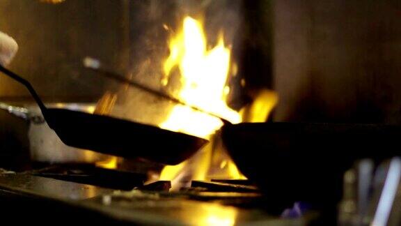 厨师在火上用平底锅烹饪-CU慢镜头