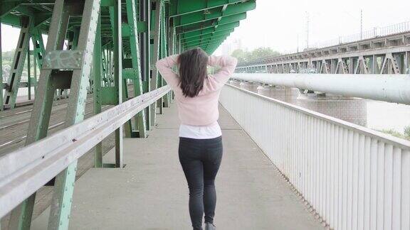 年轻女子在桥下行走