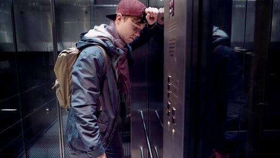 一个悲伤的男人经历了压力在地铁的电梯里下降