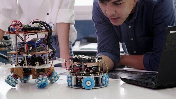 青少年工作在一个全功能可编程机器人俱乐部项目创意设计师在车间测试机器人原型科学概念