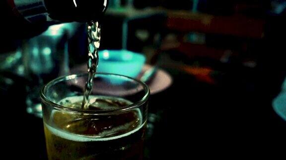 在黑暗中向玻璃杯中倒入淡啤酒