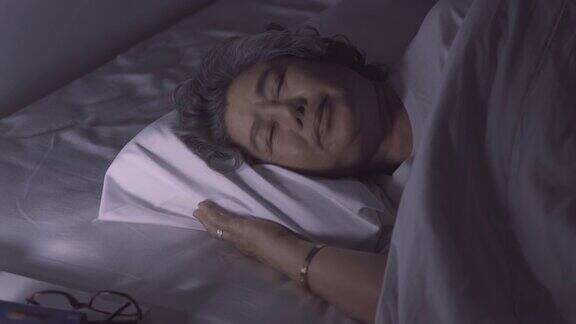 睡在床上在卧室做梦的老女人