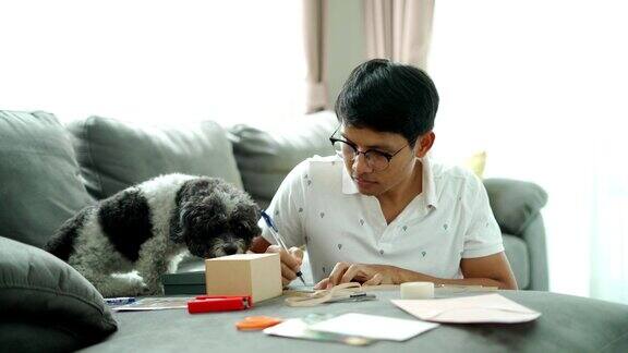 年轻的亚洲人写一个礼物盒和一张快乐的笑脸卡片