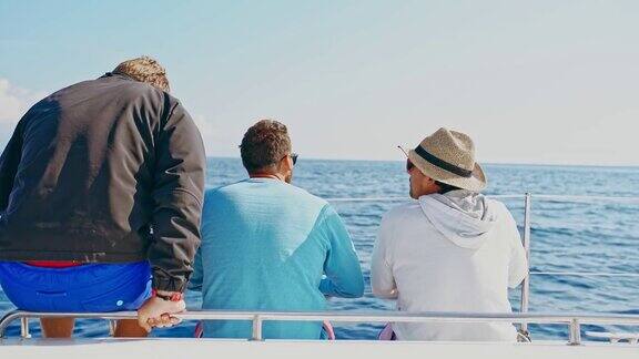 4K男人们在晴朗的帆船上在蓝色的海洋上放松和交谈实时