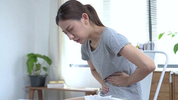 亚洲妇女遭受严重腹痛胃酸反流胃炎食物中毒阑尾炎经期疼痛