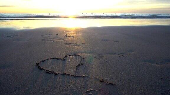 心被画在有大海和夕阳的沙滩上4k的决议