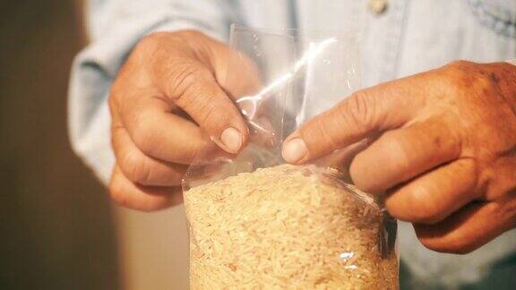 男子用手把糙米装在塑料袋里