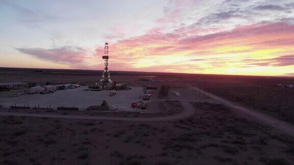 从右到左的慢摇拍摄水力压裂石油和天然气钻机在黎明或黄昏在西德克萨斯州或新墨西哥地区东南部卡尔斯巴德附近的美国南部油田