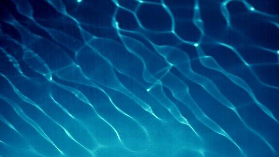清澈的蓝色透明的水反射太阳与轻微的波