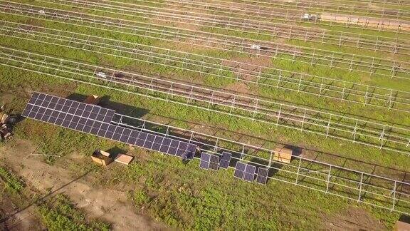 绿地上正在建设的太阳能发电厂鸟瞰图生产清洁生态能源的电板组装