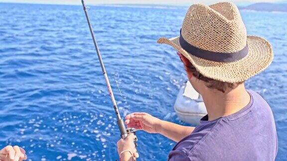 4K年轻人在阳光明媚的夏日海洋上钓鱼实时