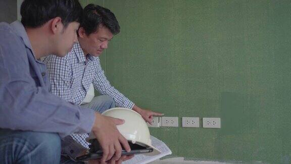 亚洲男子工程师检查正在施工的室内电源插座