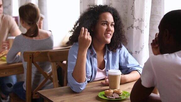 快乐的非洲女孩享受与黑人在咖啡馆约会